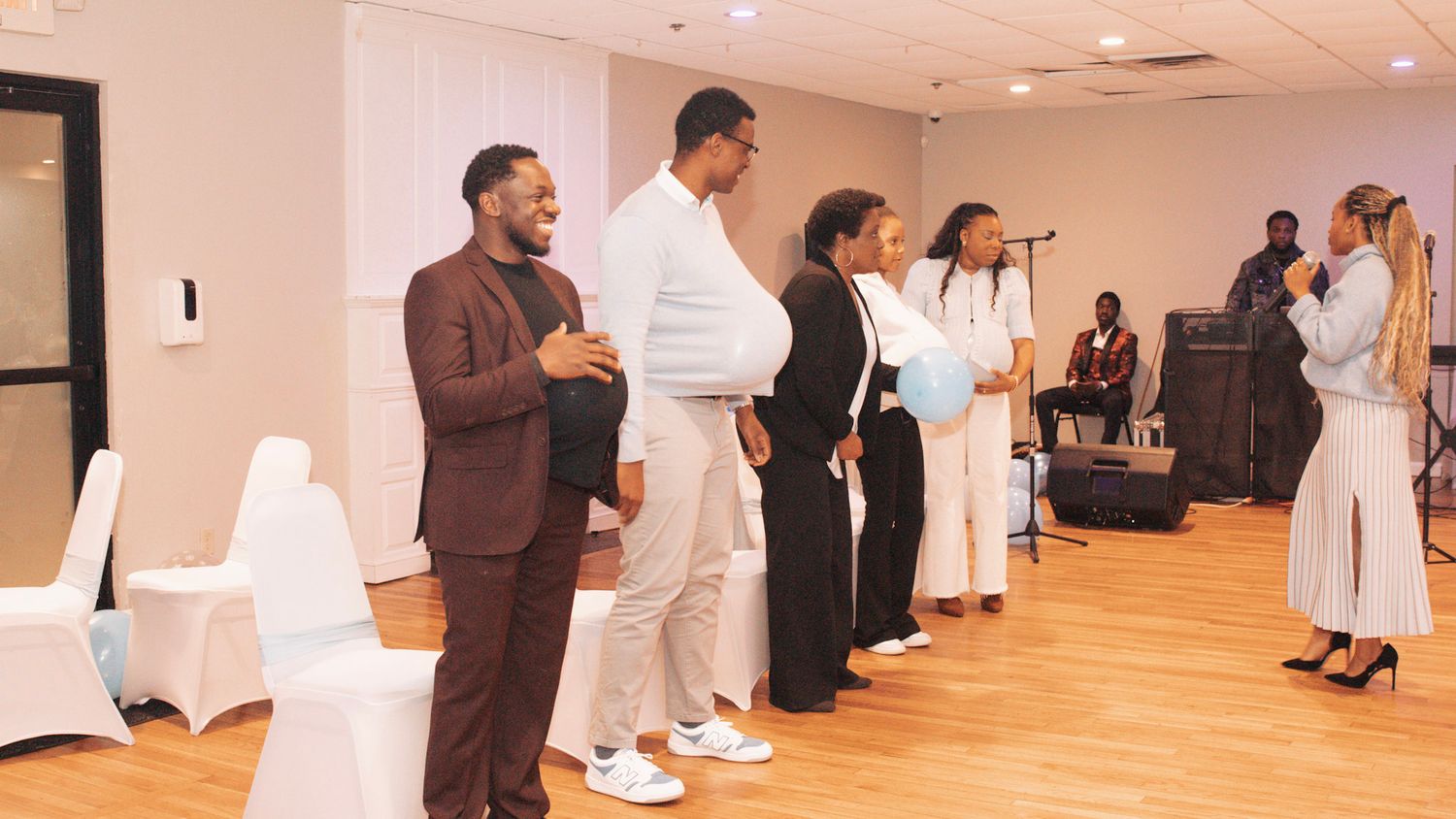 Wedding ceremony participants lined up in formal attire in a bright indoor venue.