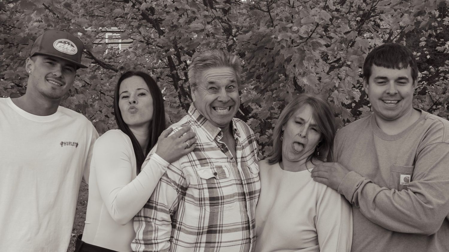 A group of people posing together outdoors in a casual setting.