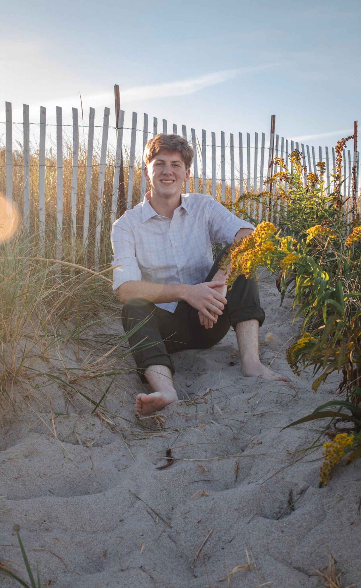 A series of photos showing someone sitting on sandy dunes near a wooden fence with yellow wildflowers in bloom.