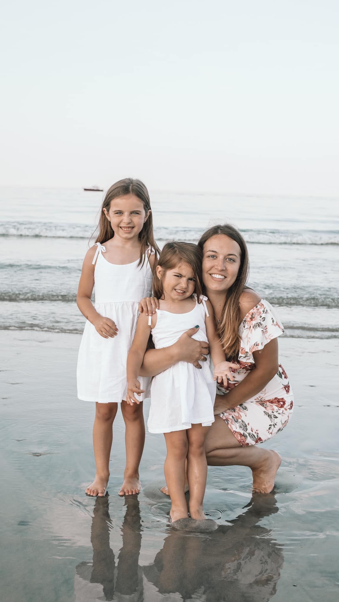 Heartwarming beach photos with white outfits against the ocean backdrop.