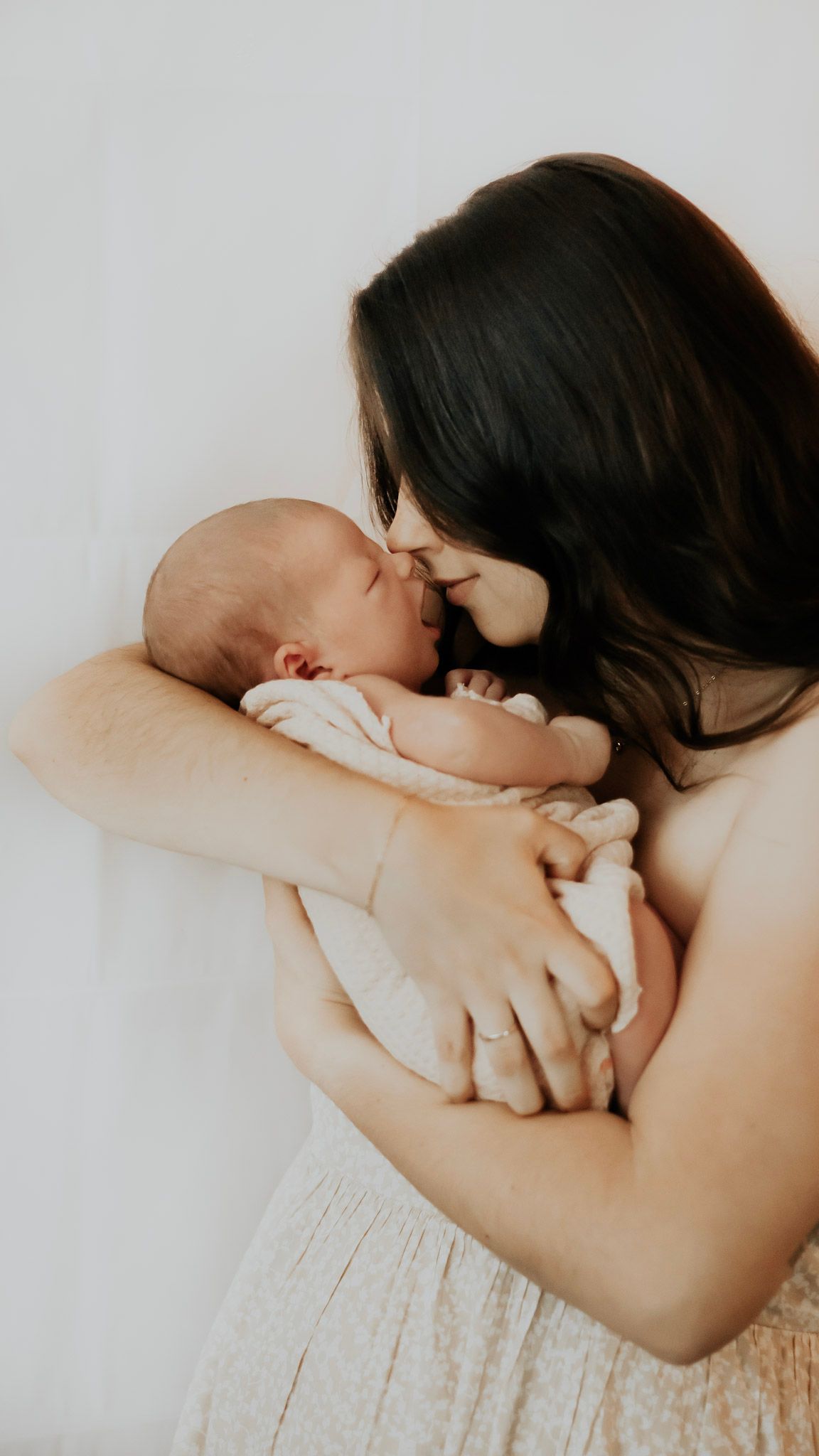 Intimate black and white portraits of a mother holding and bonding with her newborn baby.