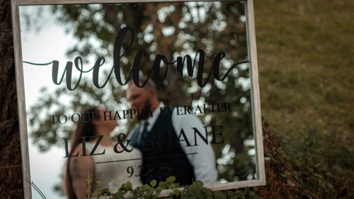 A welcome sign for a wedding displayed with blurred background.