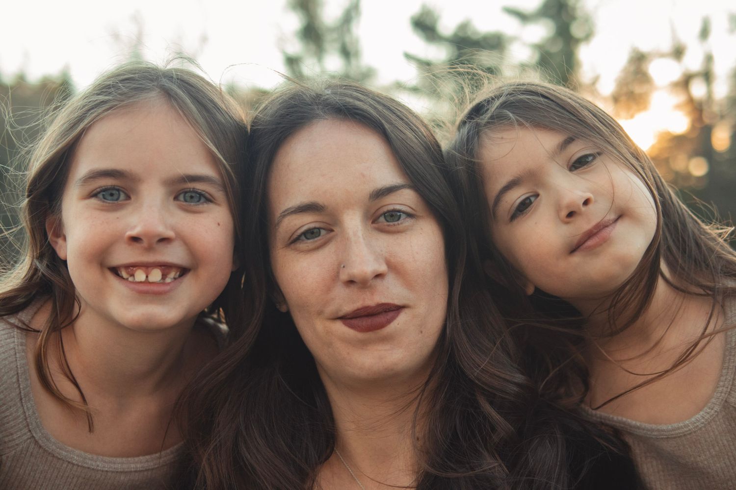 A series of candid close-up photos showing joyful expressions and tilted heads against various outdoor backgrounds.