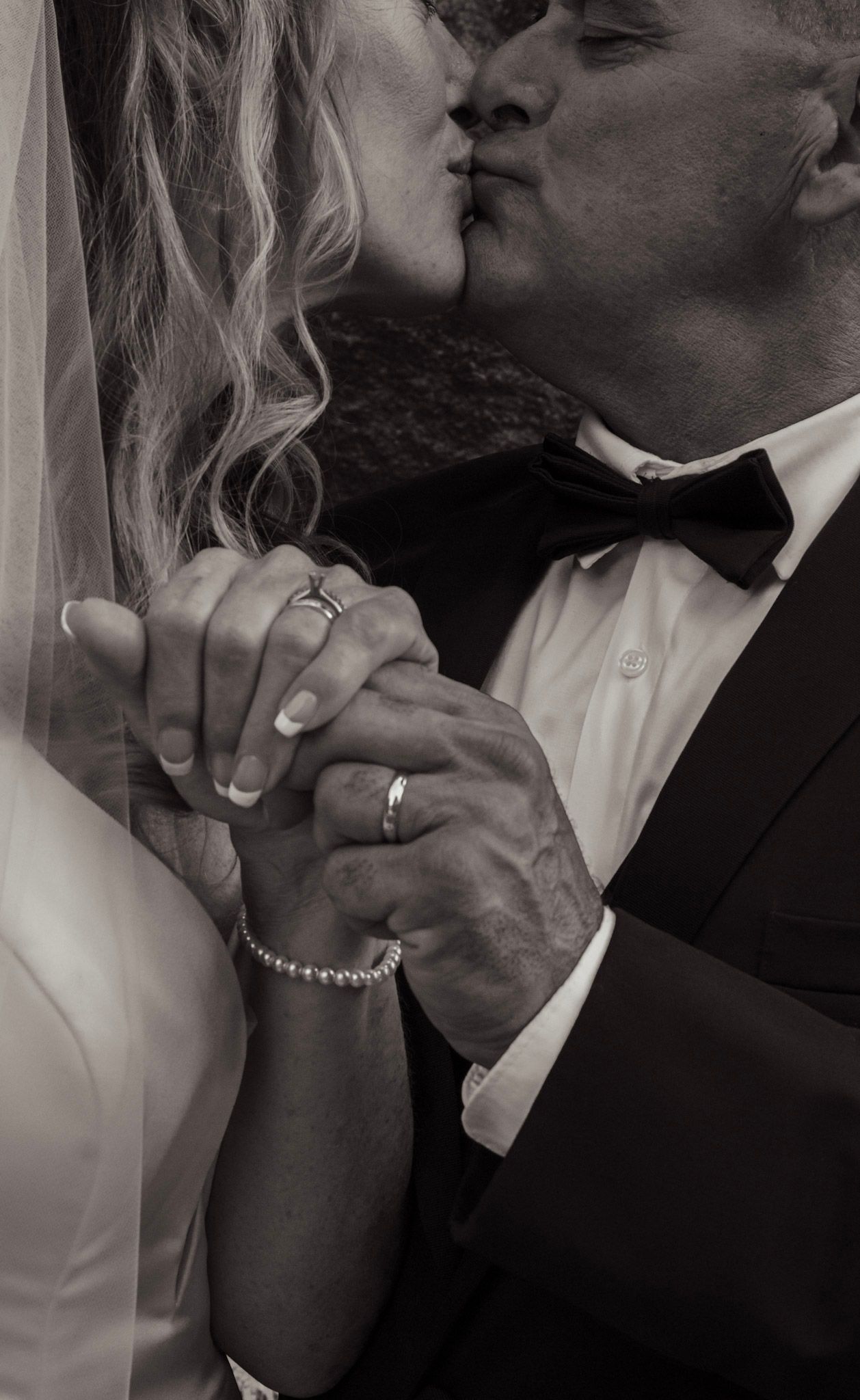 A romantic black and white photo series showing close-up moments of a couple on their wedding day.