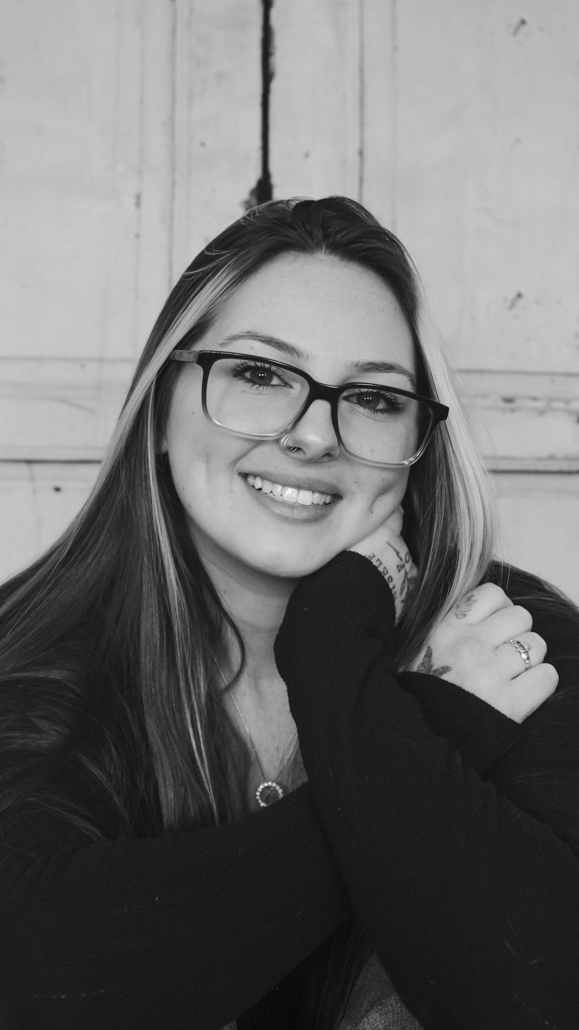 Black and white photo series showing a person with glasses smiling and posing in different angles.