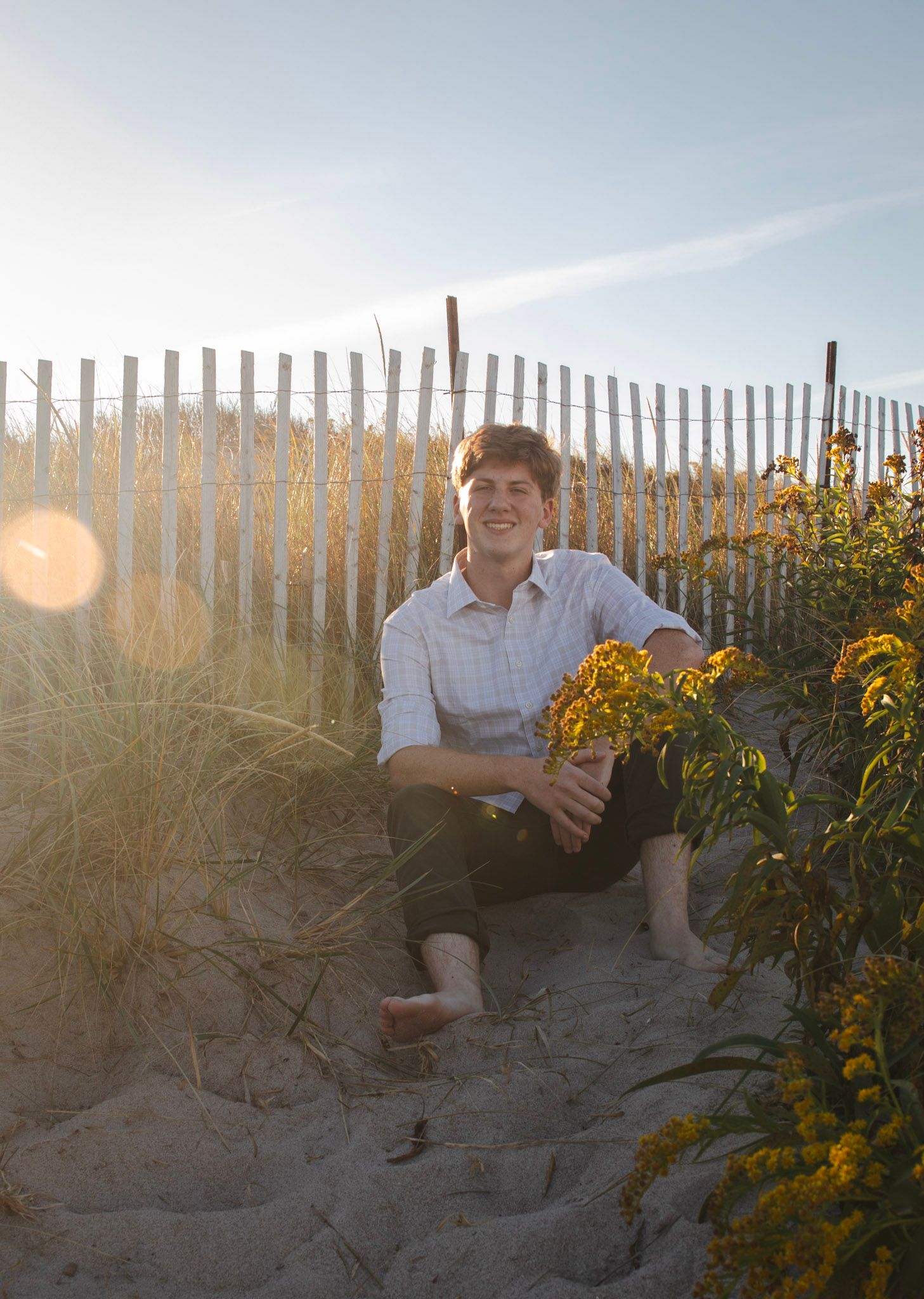 A series of photos shows someone sitting on sandy dunes at sunset with yellow wildflowers and a wooden fence in view.