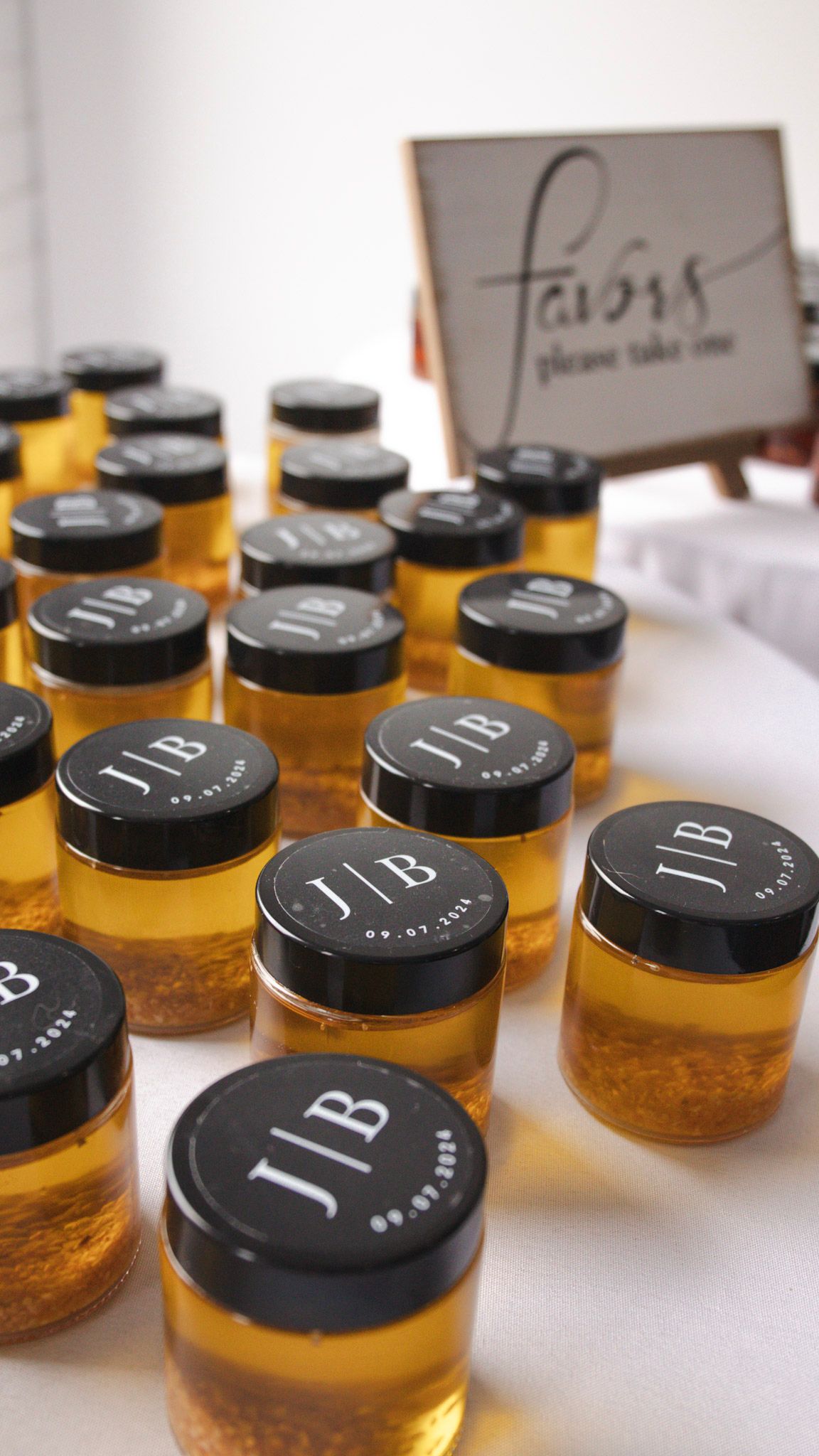 Wedding favor jars with black lids arranged on display.