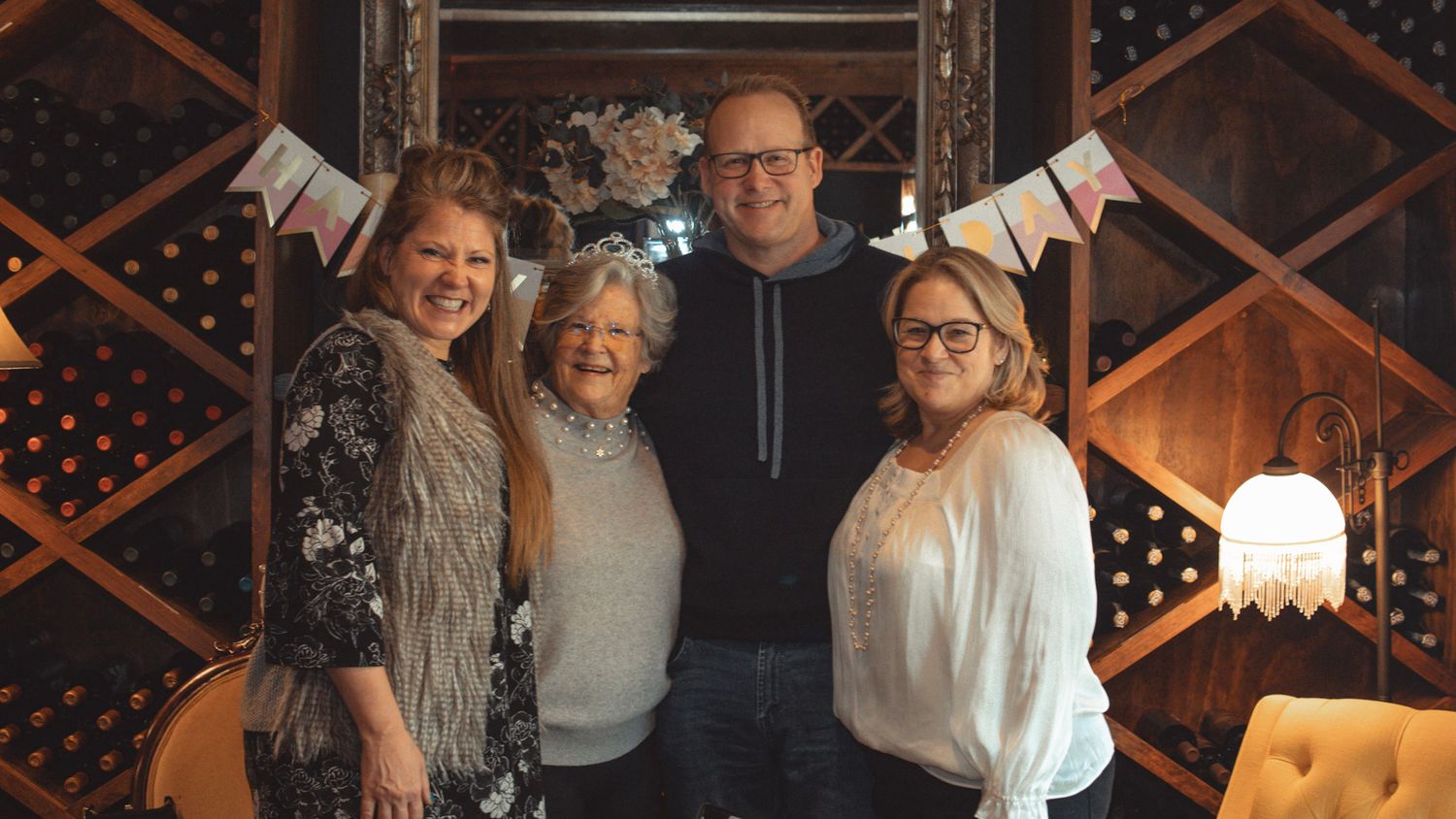 A celebration gathering in a wine cellar with decorative bunting and warm lighting.