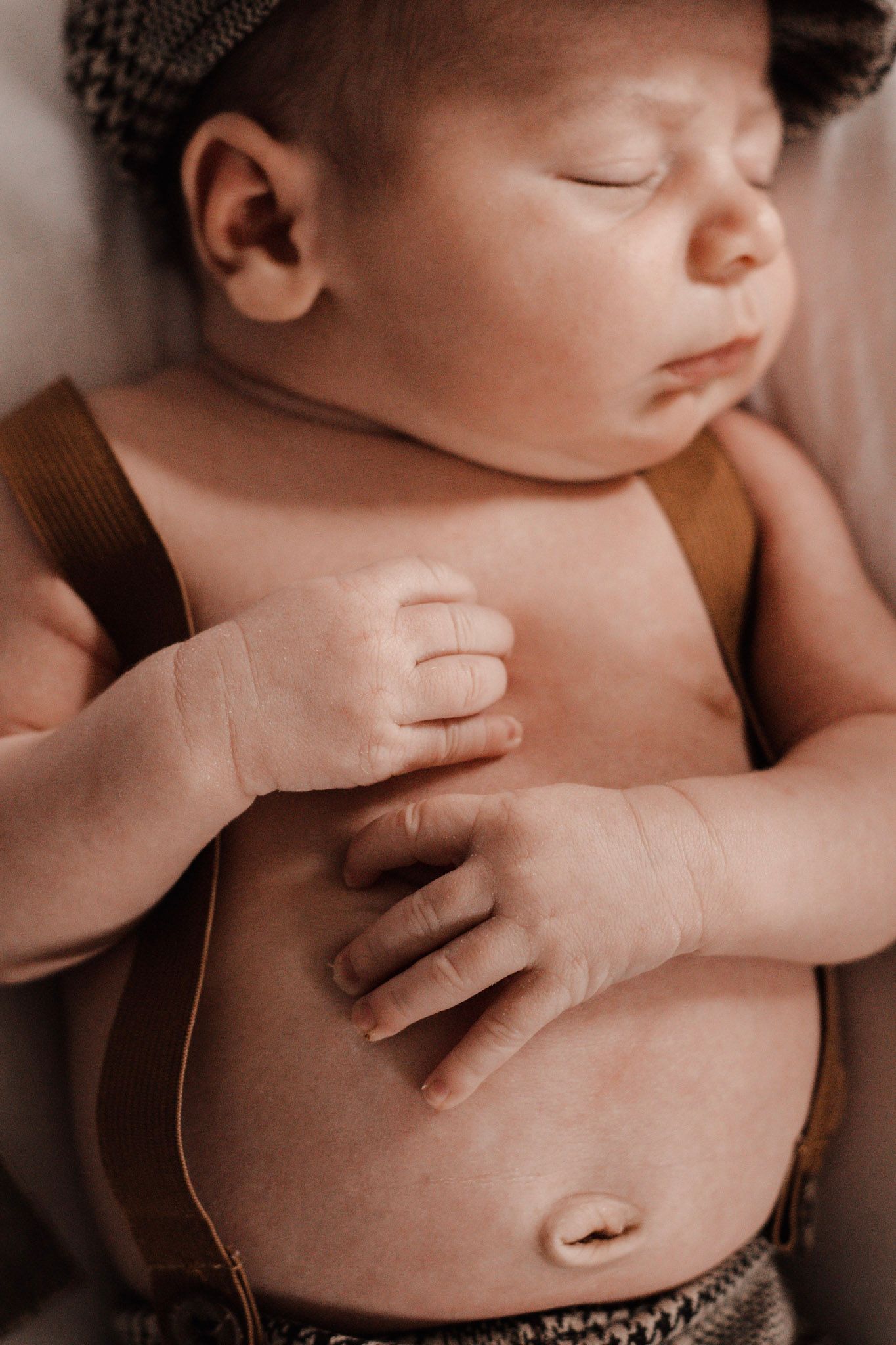 Close-up shot of gentle hands caressing a baby's bare torso.