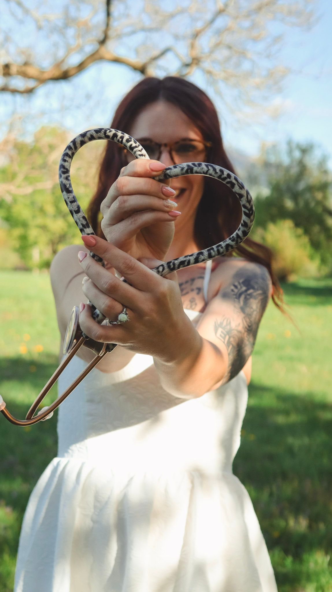 Person holding decorative sunglasses outdoors against a spring background.