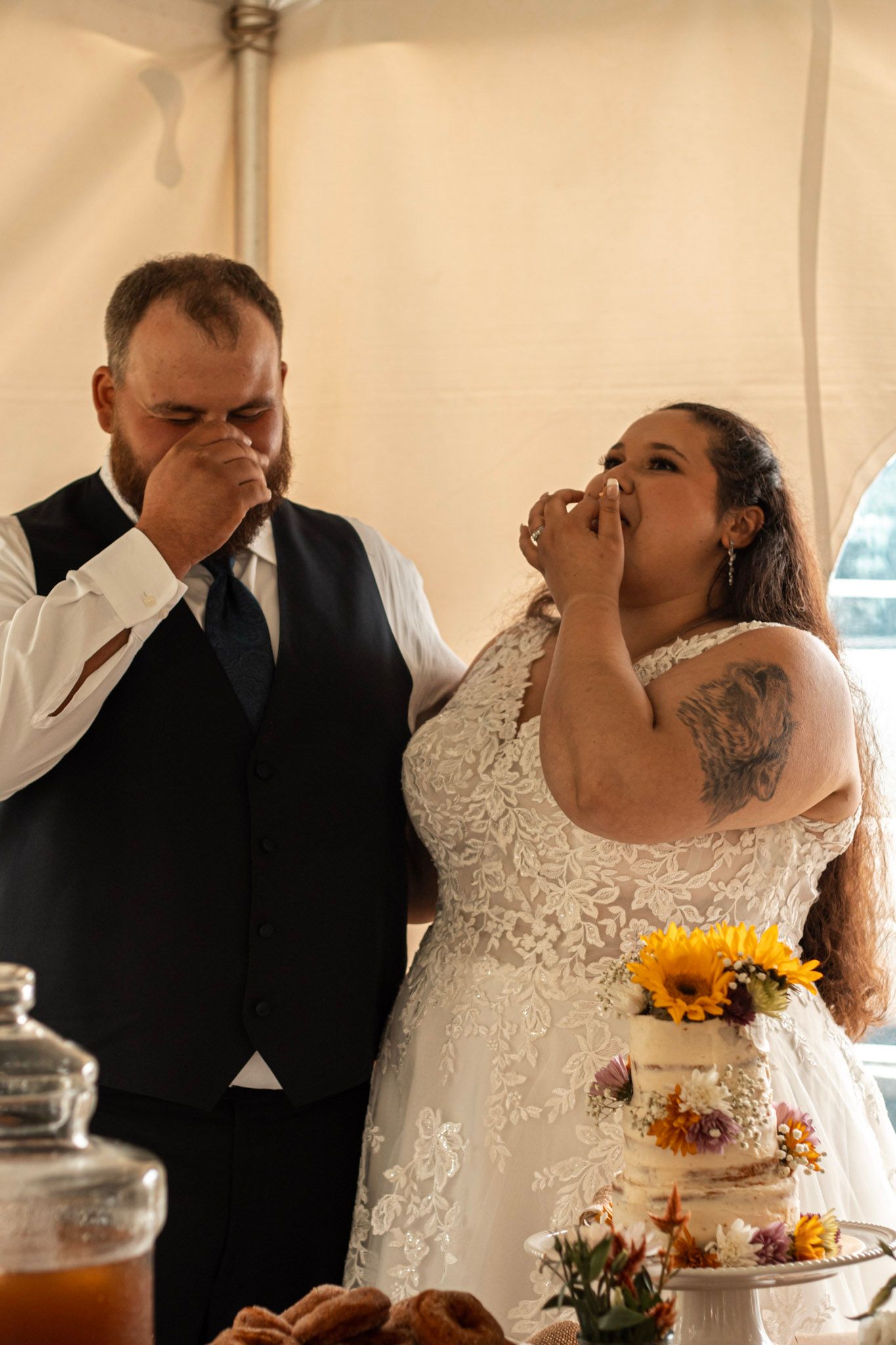 Wedding cake cutting ceremony with sunflowers and rustic decor.