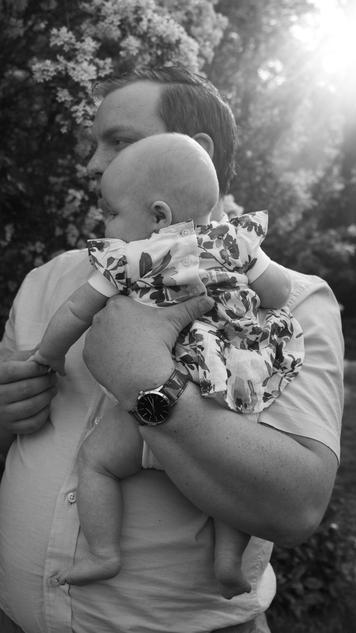 Black and white photo sequence showing an intimate embrace between two people in a sunlit outdoor setting.