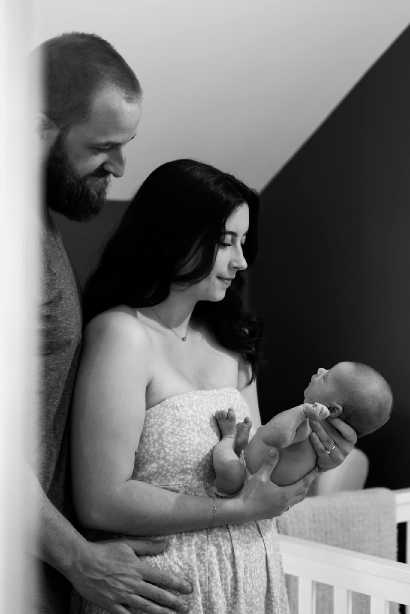 A tender family moment with a newborn baby in a nursery setting.