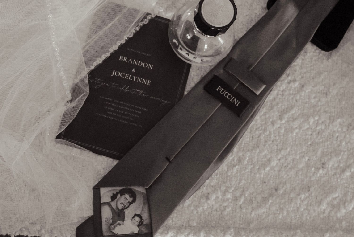Perfume bottles and luxury beauty products arranged on a white textured surface.