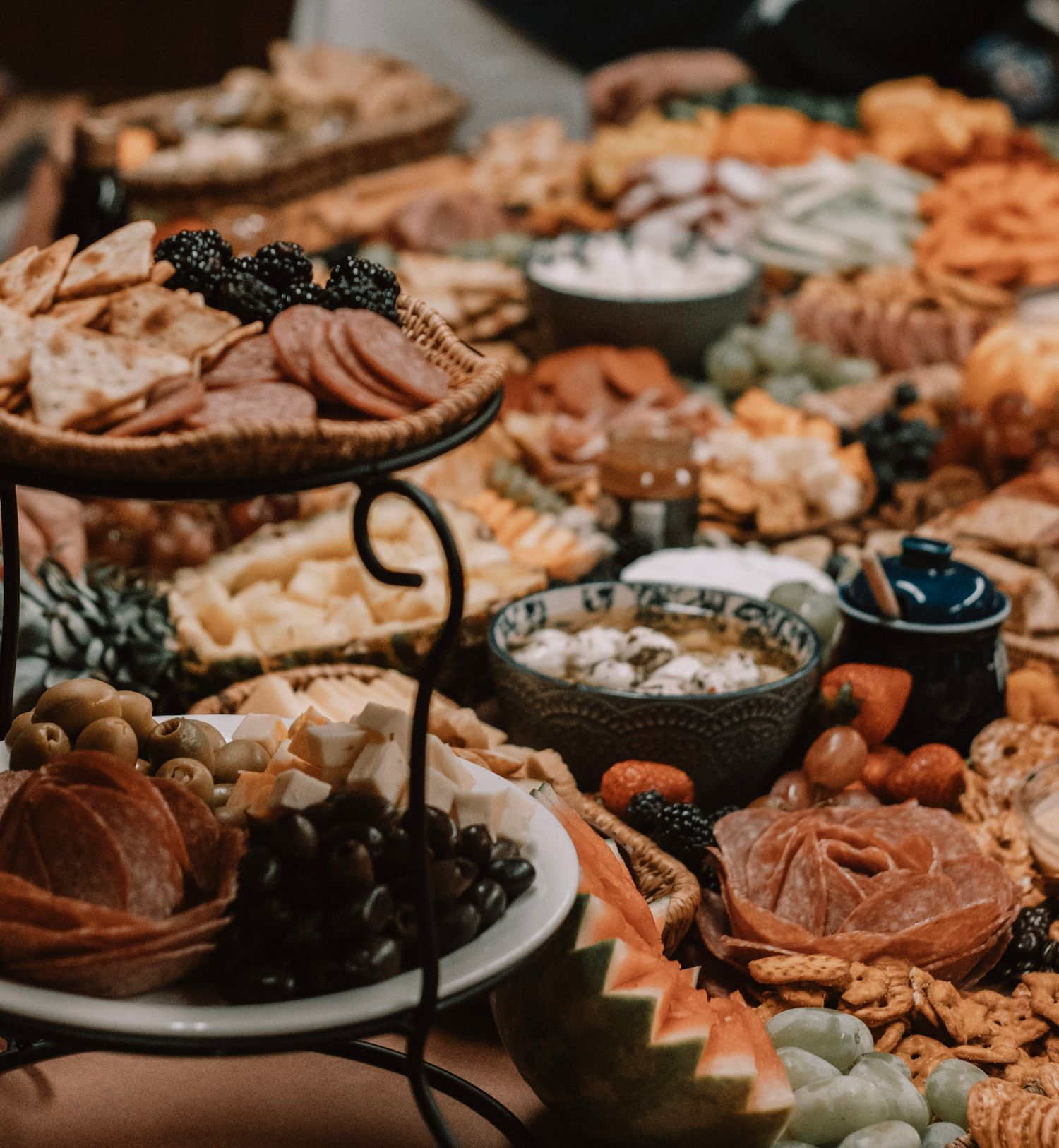A rustic dessert table spread with various pastries, chocolates, and sweet treats arranged on plates and serving stands.