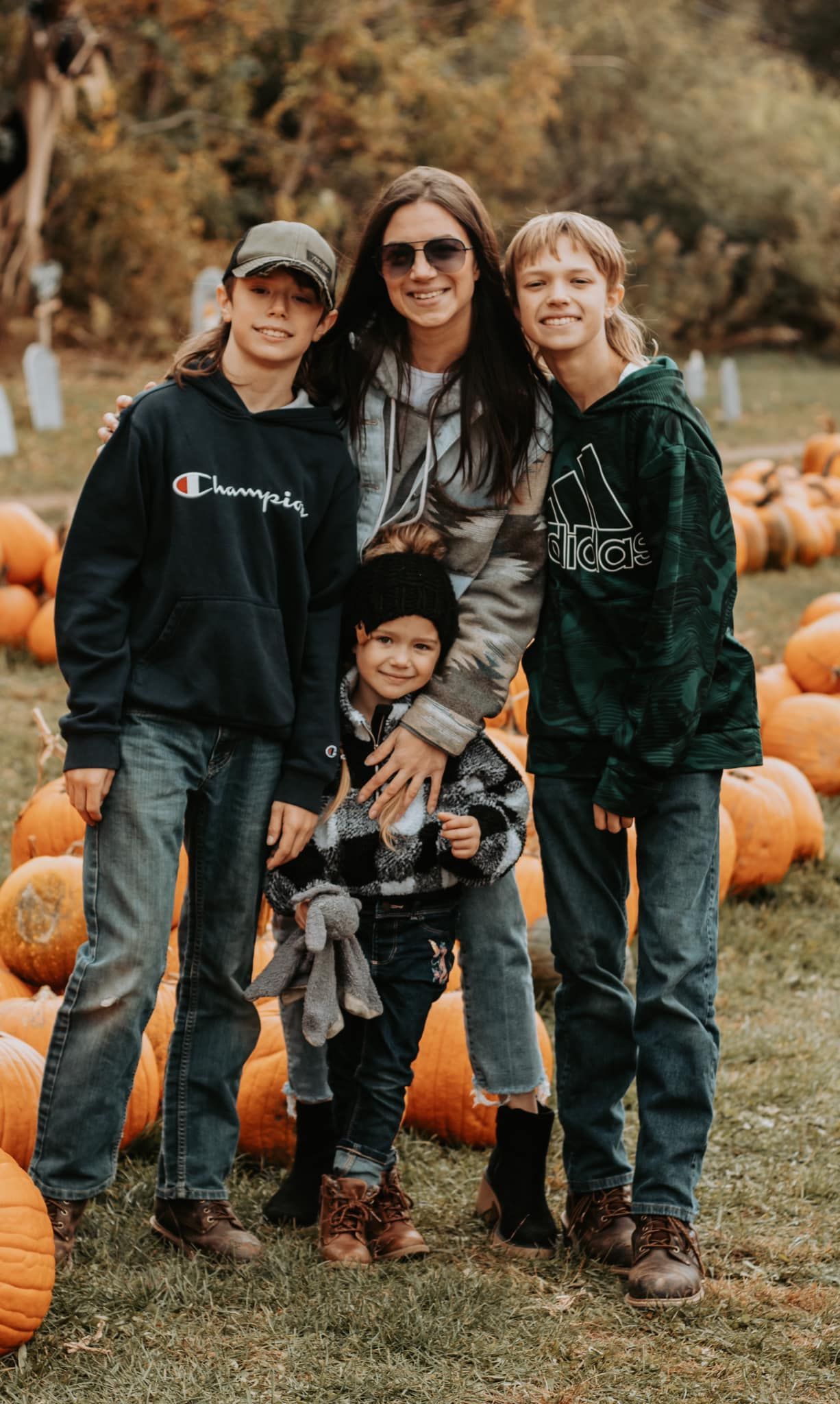 Group portrait at pumpkin patch during autumn season.