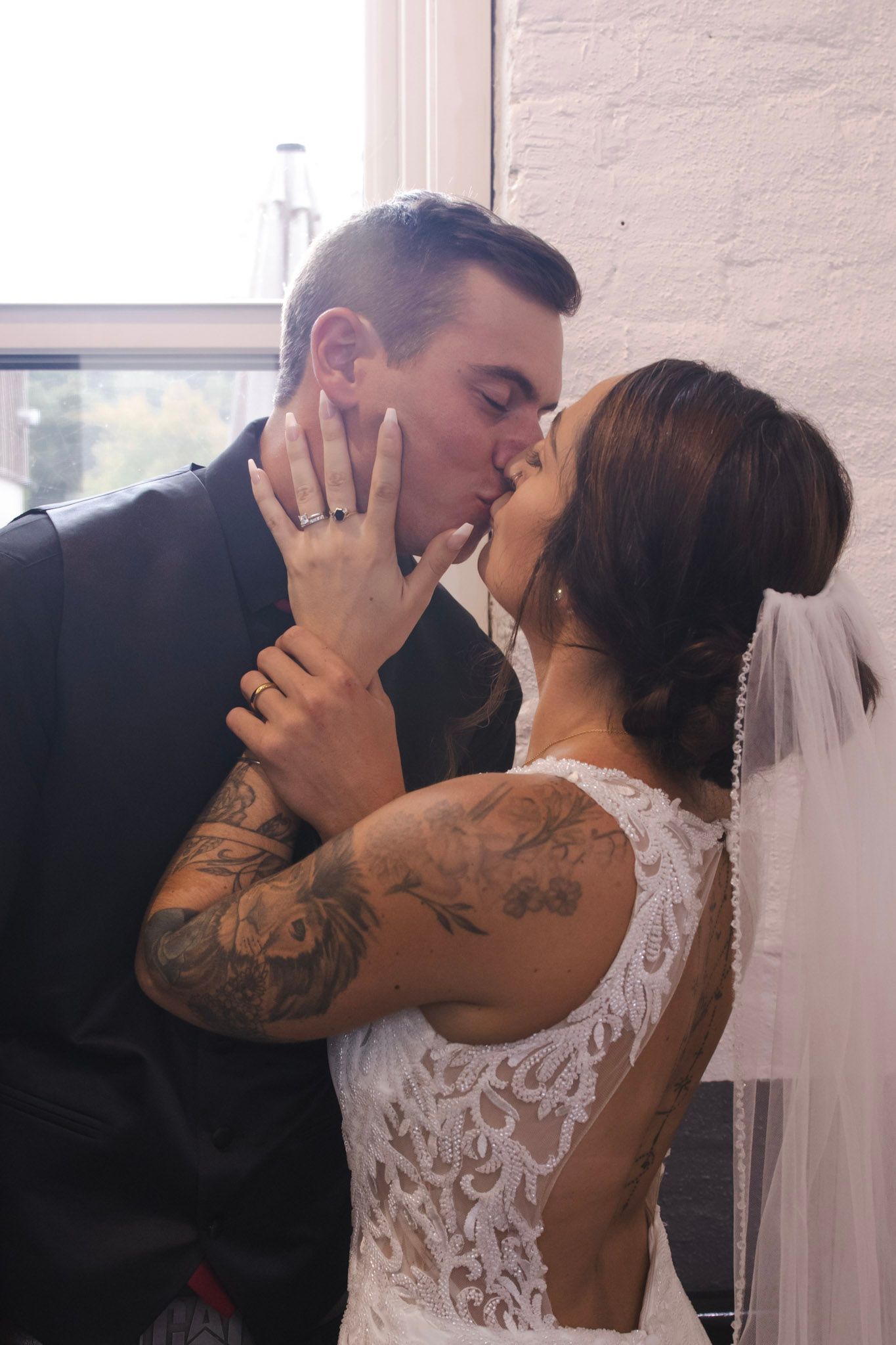 A romantic sequence of wedding photos showing a couple sharing intimate kisses in a bright indoor setting.