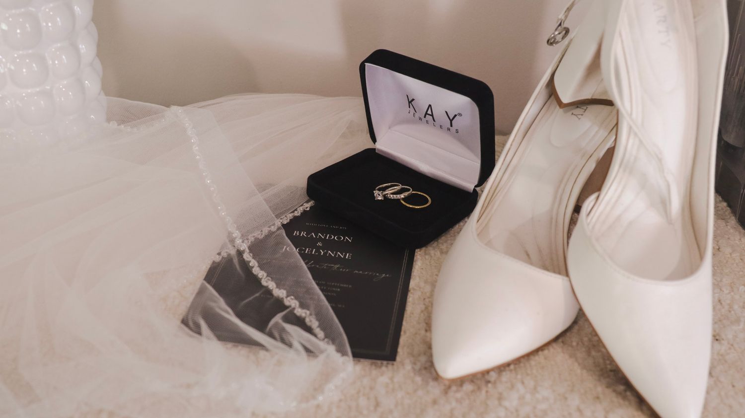White bridal heels and accessories arranged on a light surface.