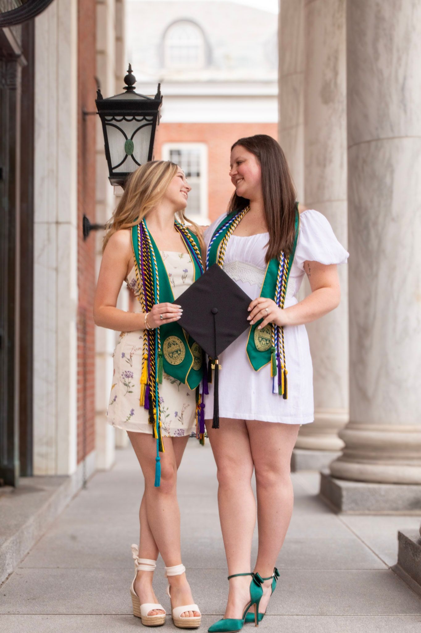 Two people wearing green beaded necklaces pose together in front of white columns in a progression of casual shots.