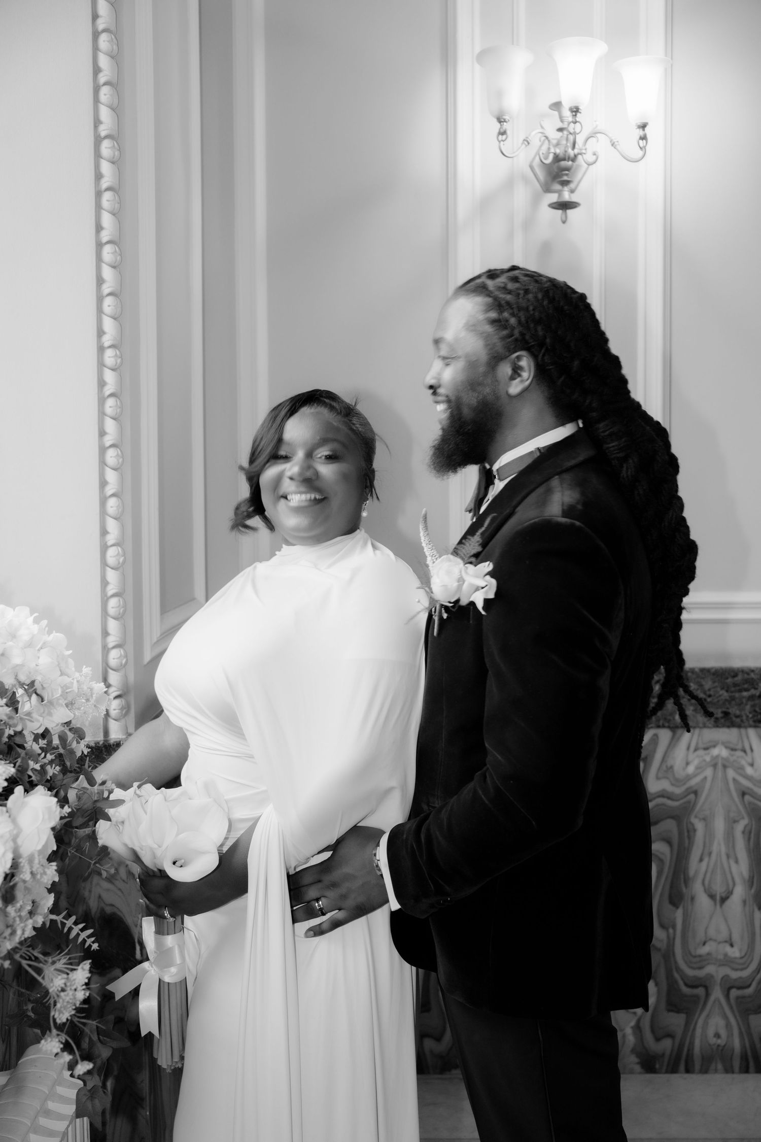 A couple shares joyful laughter during their wedding celebration in an elegant indoor setting.