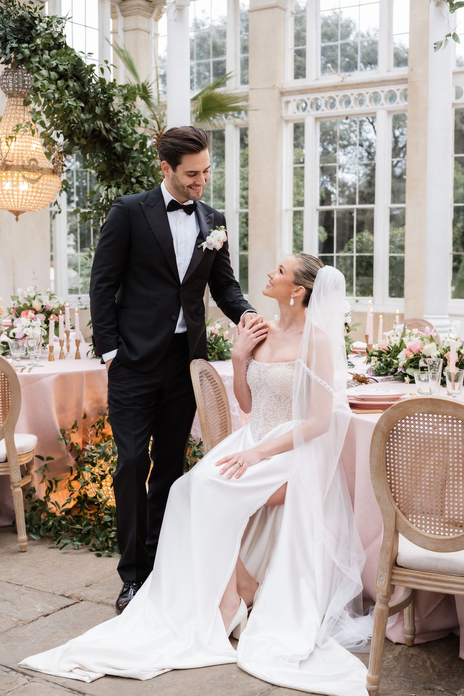 Elegant wedding photos in a sunlit conservatory with ornate furniture and floral decorations.