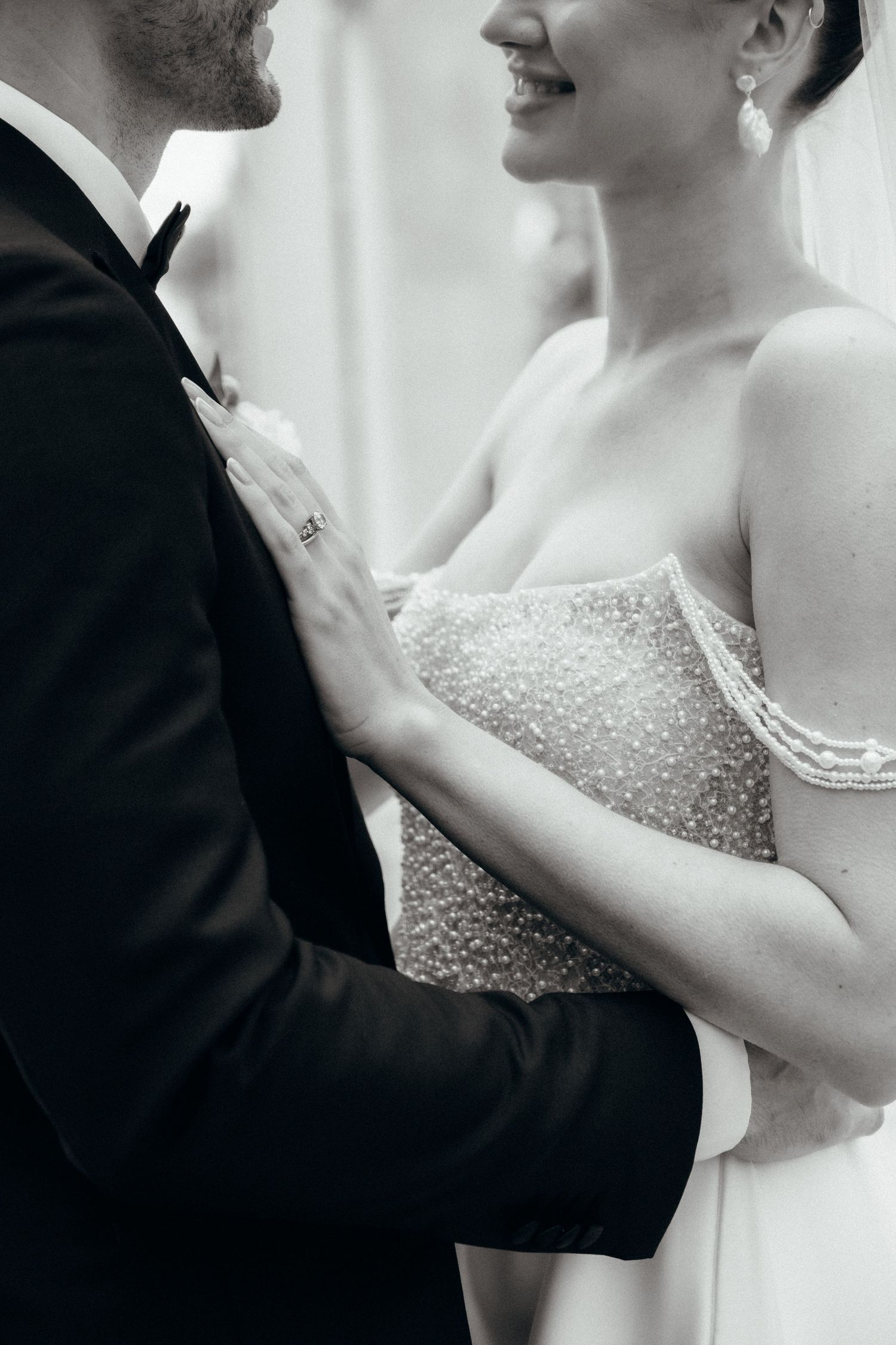 Close-up black and white photo of wedding couple in formal attire.