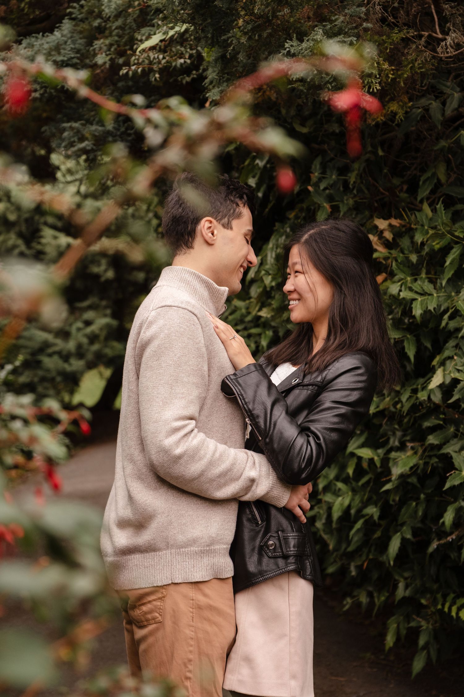 A tender embrace captured between a couple in an autumn garden setting.