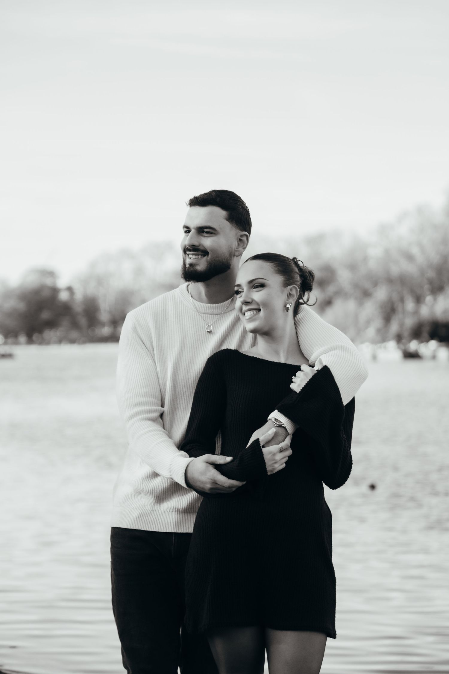 Romantic black and white waterfront photoshoot showing a couple in casual attire.
