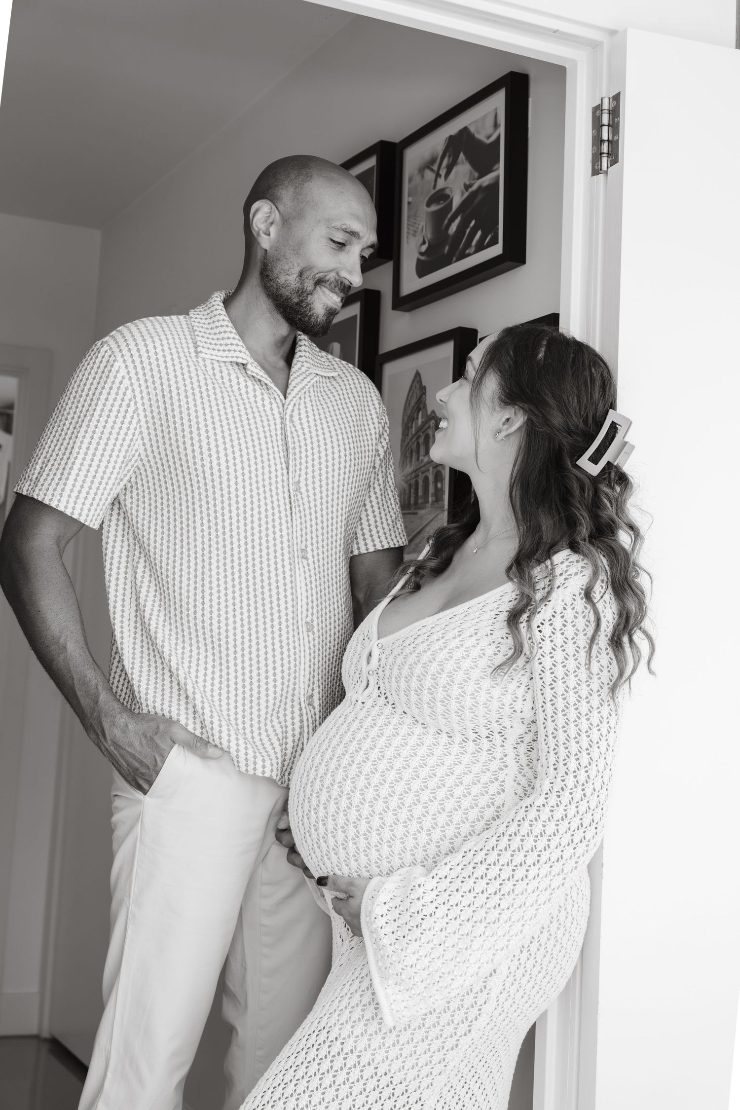 Couple in white and polka dot outfits share intimate moments in a bright indoor setting.