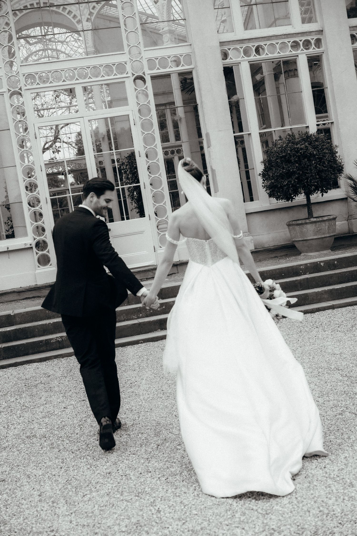 A sequence of wedding photos showing a couple walking together on a gravel path outside an elegant building.