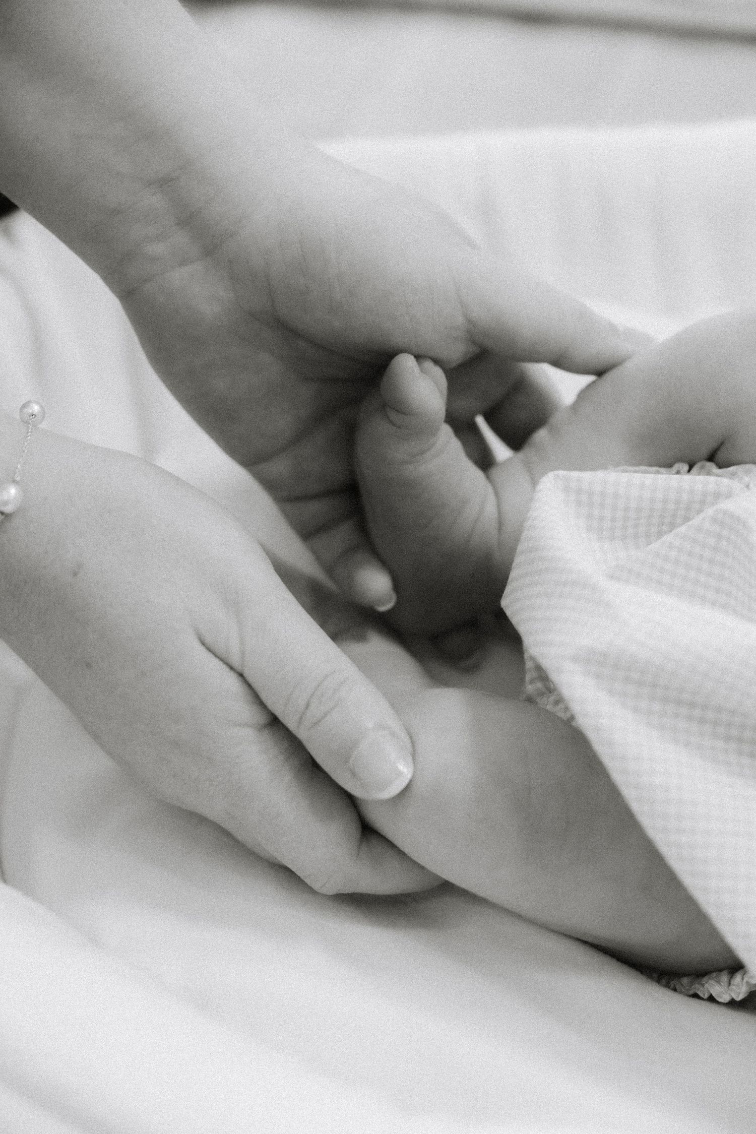 Close-up sequence of hands holding a white textured fabric in black and white.