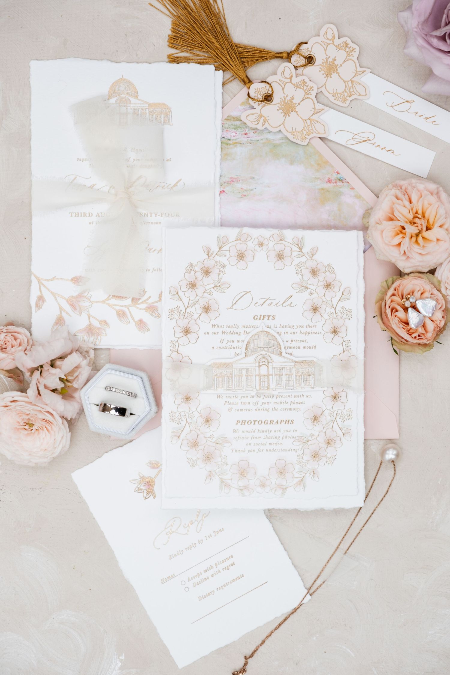 Delicate wedding invitations in blush pink and white with floral accents and calligraphy.