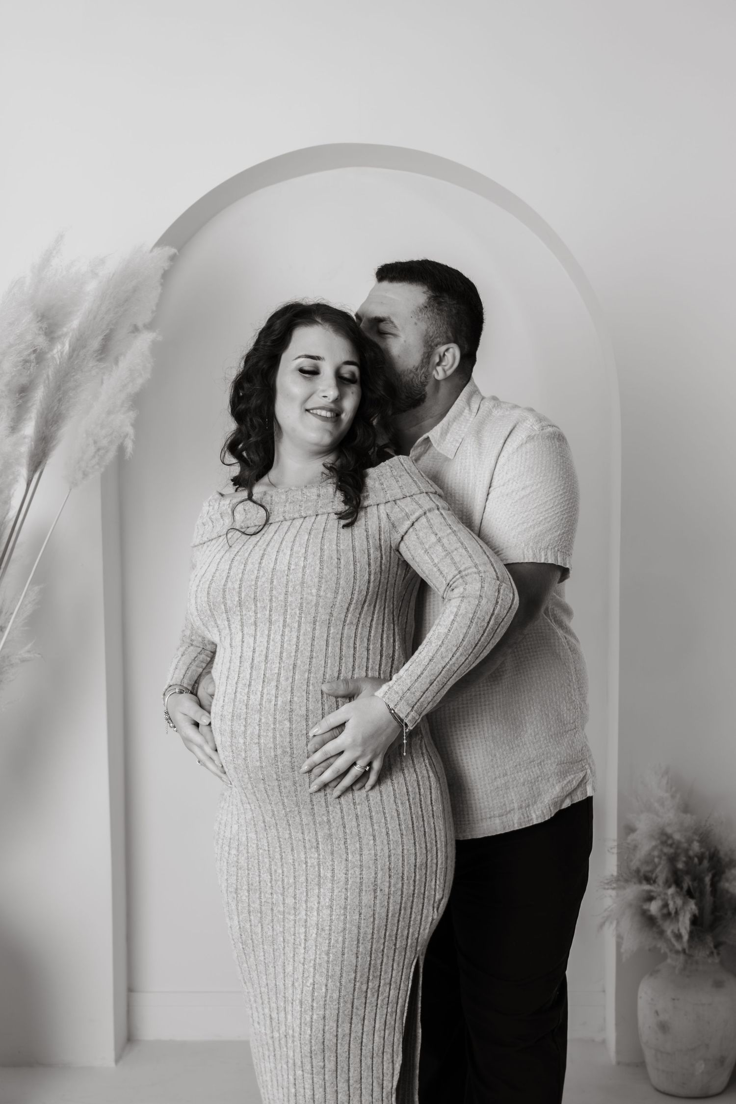 An intimate black and white maternity portrait session with minimal studio styling.