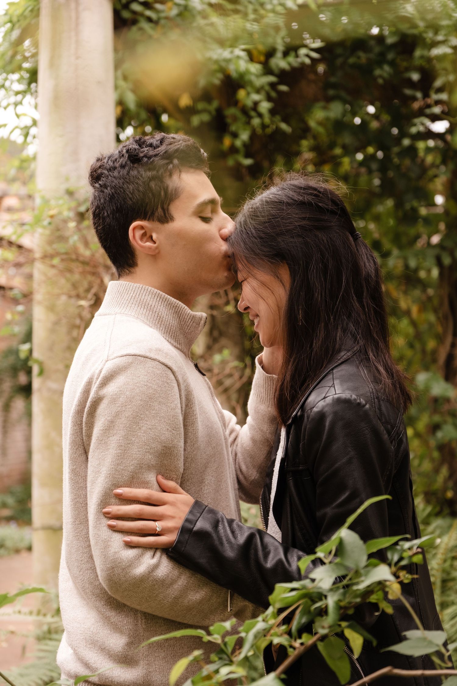 An intimate moment shared between a couple in a lush garden setting.