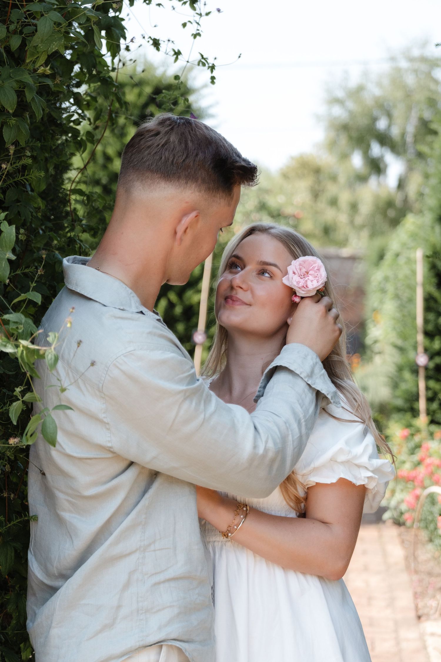 A romantic couple shares intimate moments in a garden setting with soft lighting.