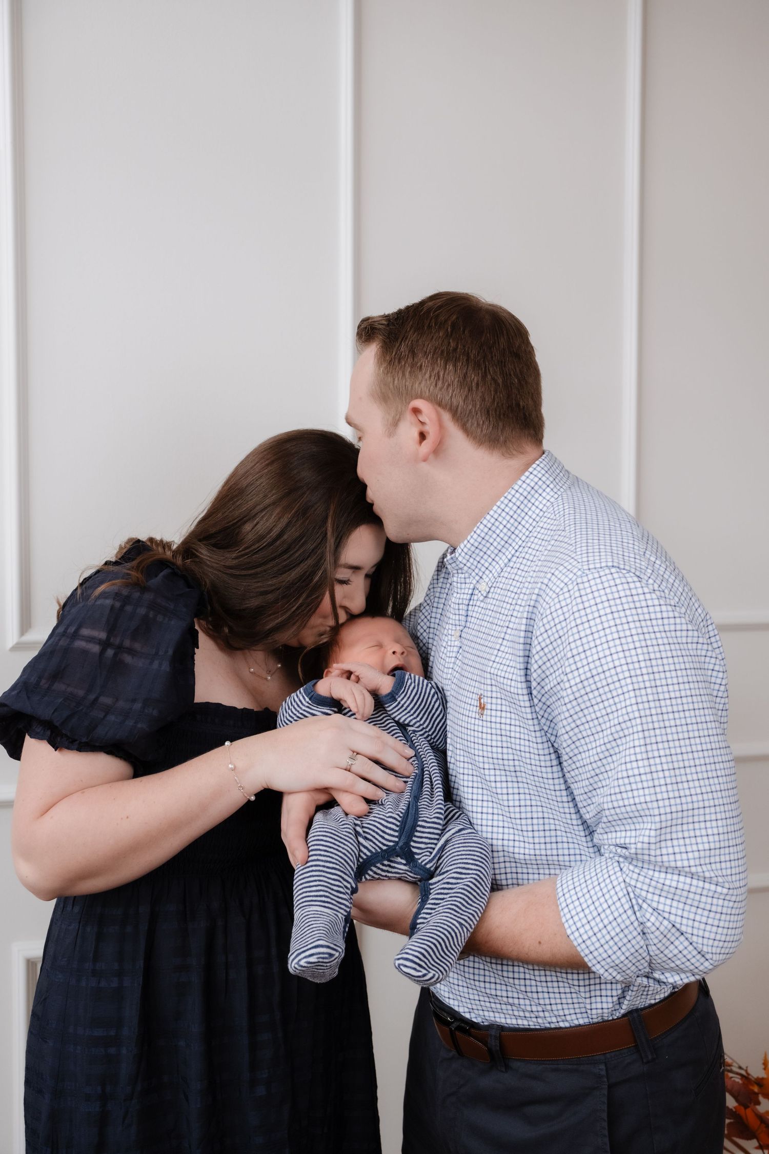 Family embracing and bonding with a newborn baby in a tender moment.