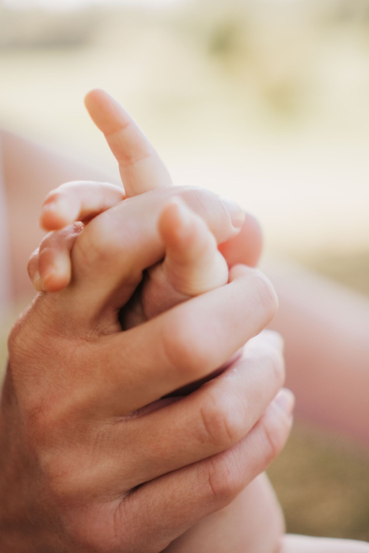 Baby and mum holding hands during first birthday milestone session
