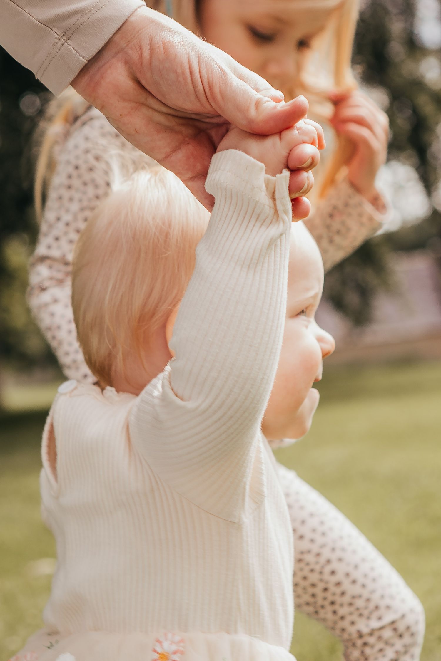 baby girl surrounded by love during her first birthday session as they take a little walk.