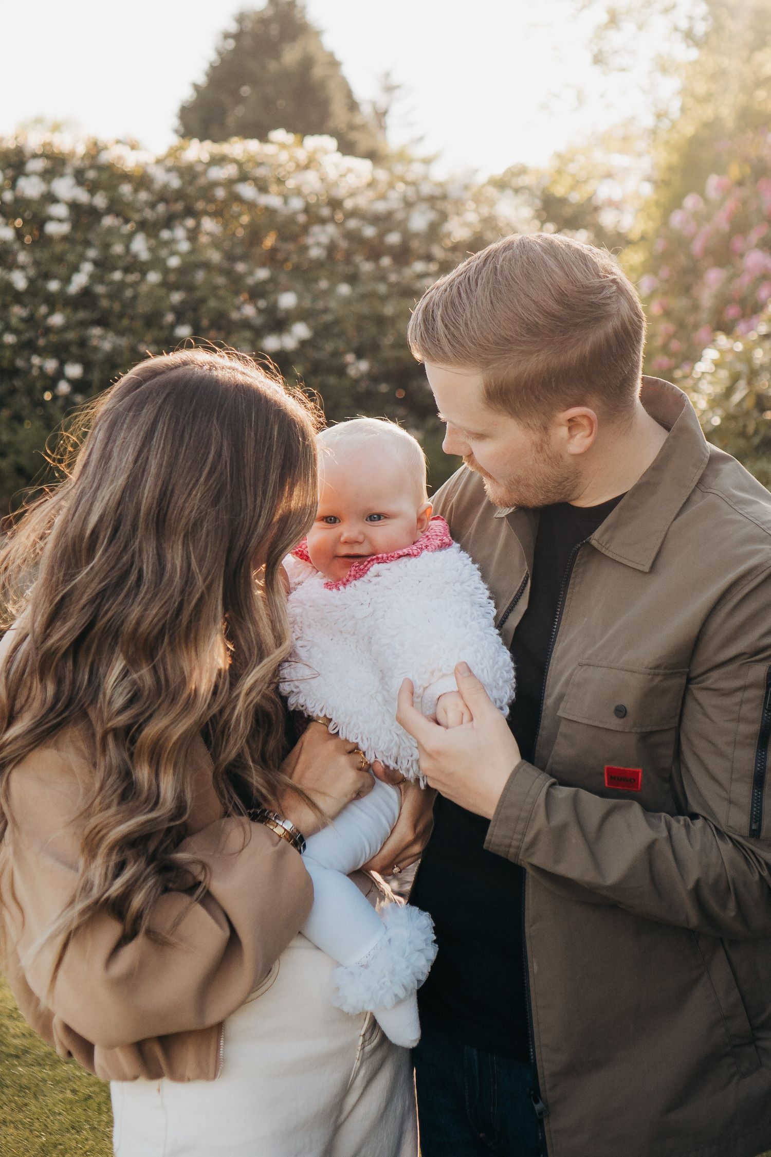 mum, dad and baby girl cuddled up together in a gorgeous evening family session