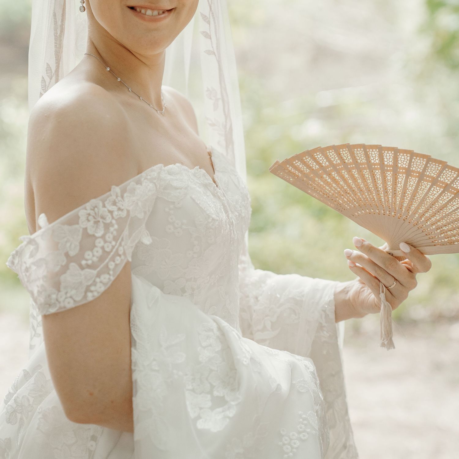 Elegante bruidsdetails met een kanten trouwjurk en decoratieve houten waaier – bruidsfotografie, trouwfotograaf, trouwdag, Nederland