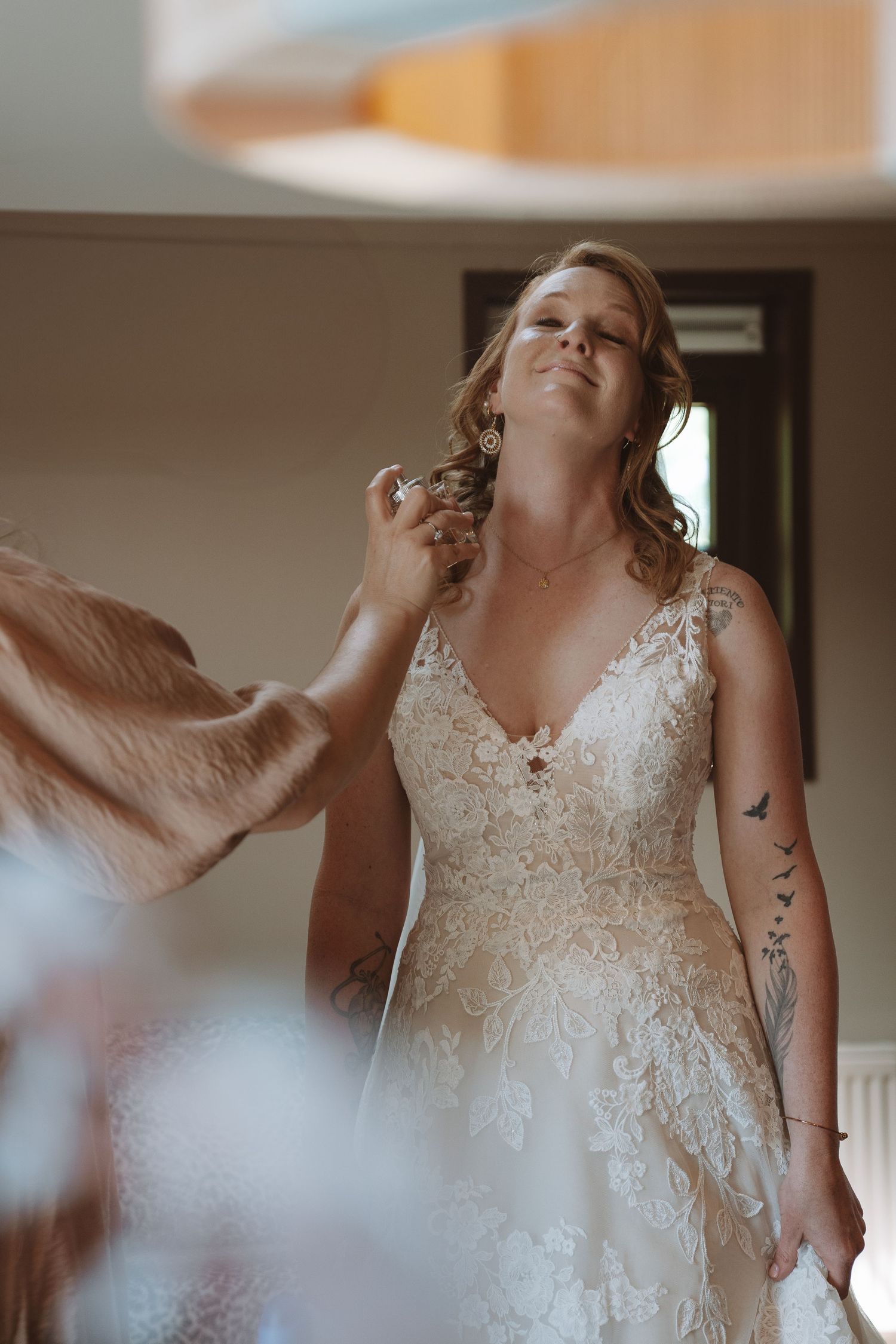 Bruid aan het klaarmaken met spuitje parfum van de maid of honour – bruidsfotografie, bridal details, trouwdag, Nederland
