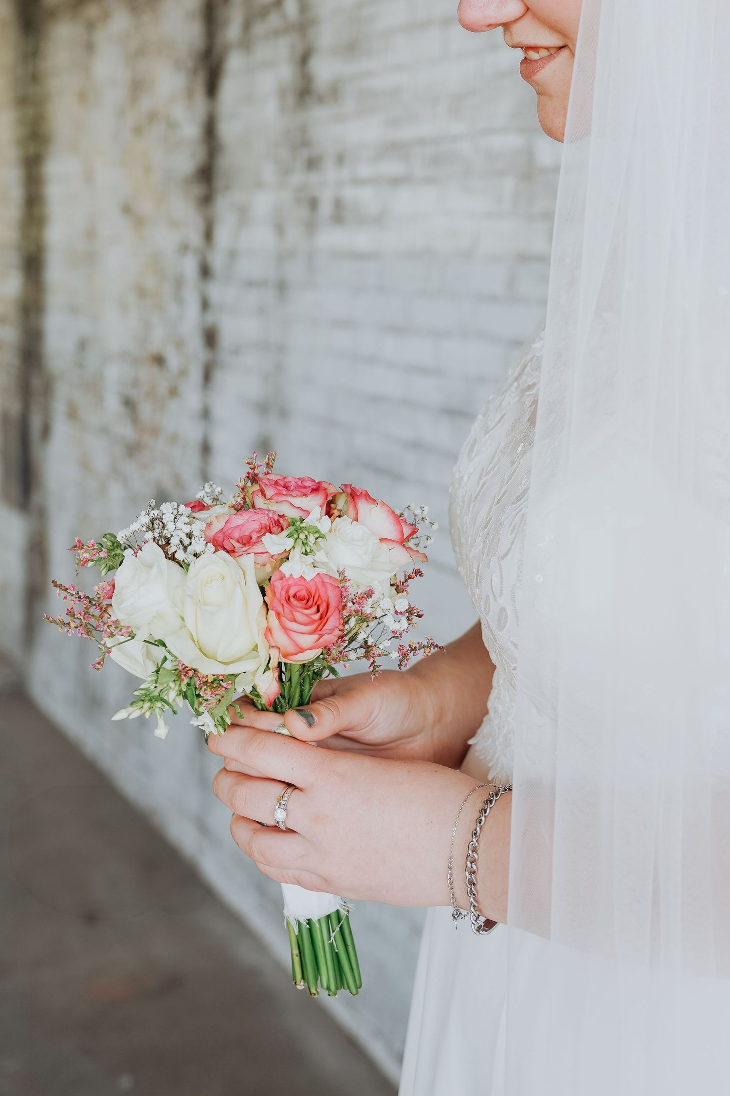 Close-up van bruidsboeket met roze en witte rozen, vastgehouden door handen – bruidsfotografie, bridal details, trouwdag, Nederland