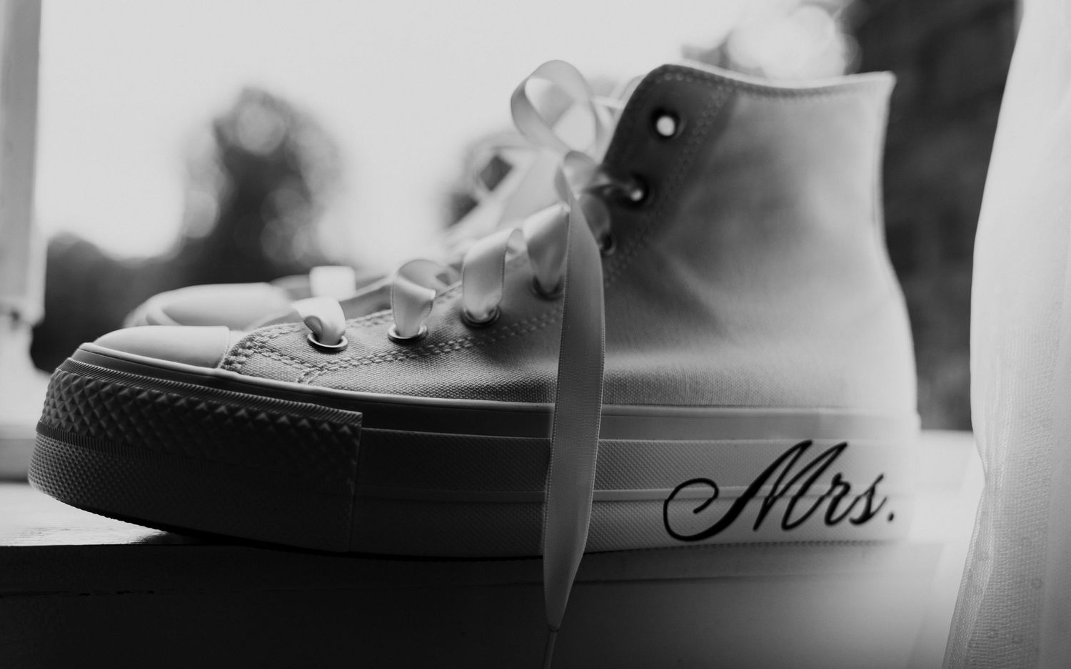Zwart-wit foto van witte sneaker met 'Mrs.' tekst – bruidsfotografie, bridal details, trouwdag, Nederland