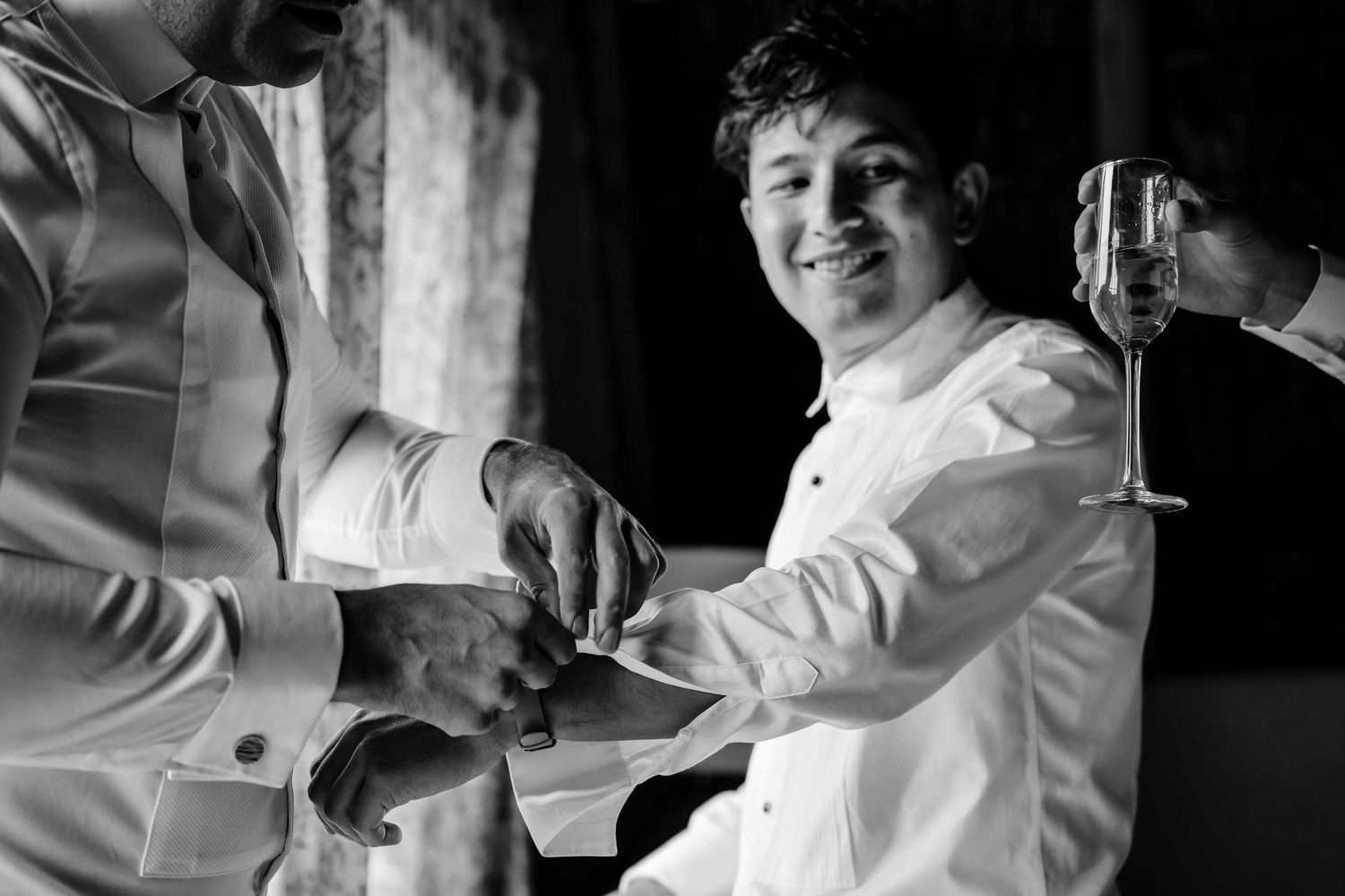 Black and white photo series showing a person in a white shirt sitting and smiling in different poses.