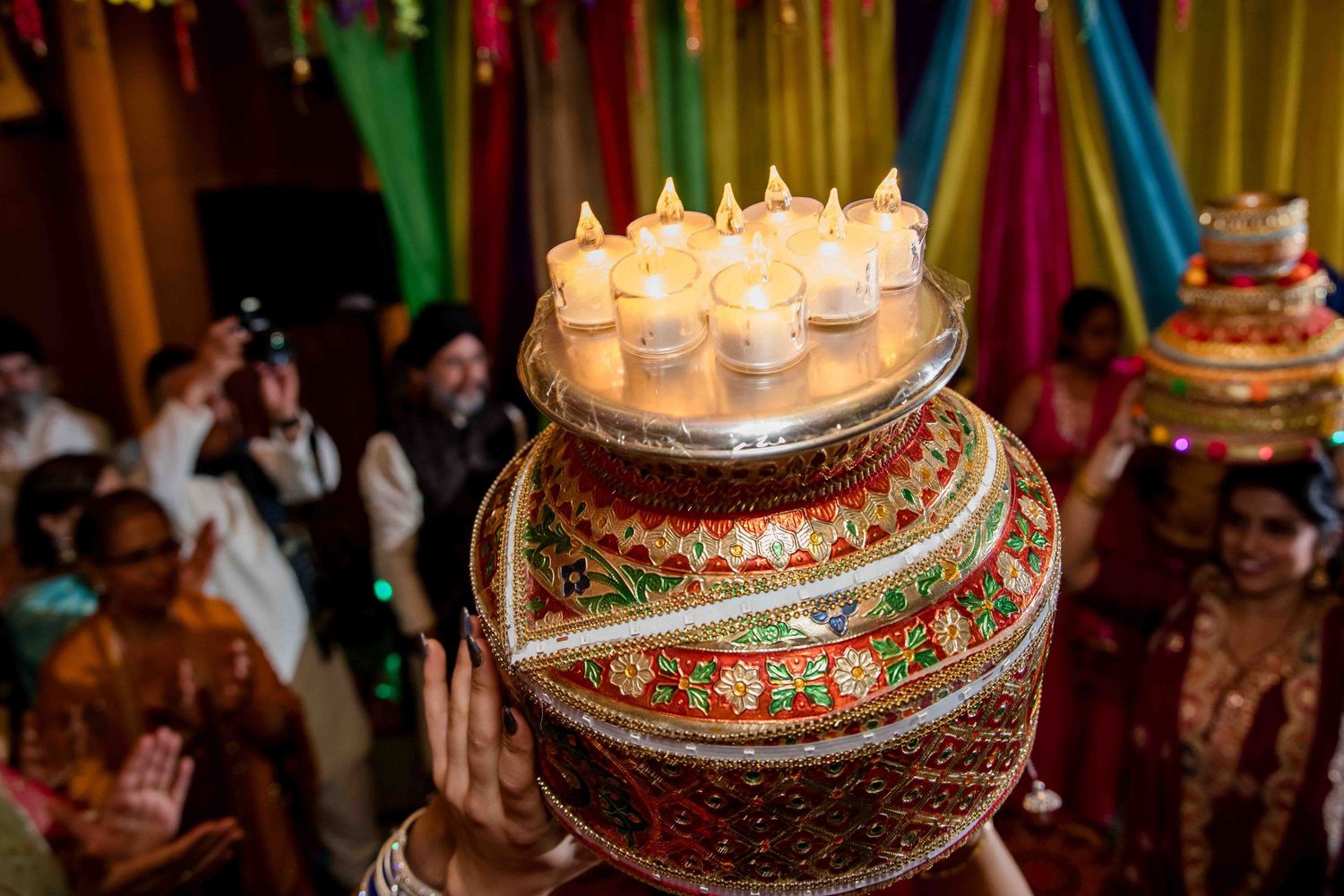 Decorative tiered display with lit electronic candles at traditional Indian celebration.