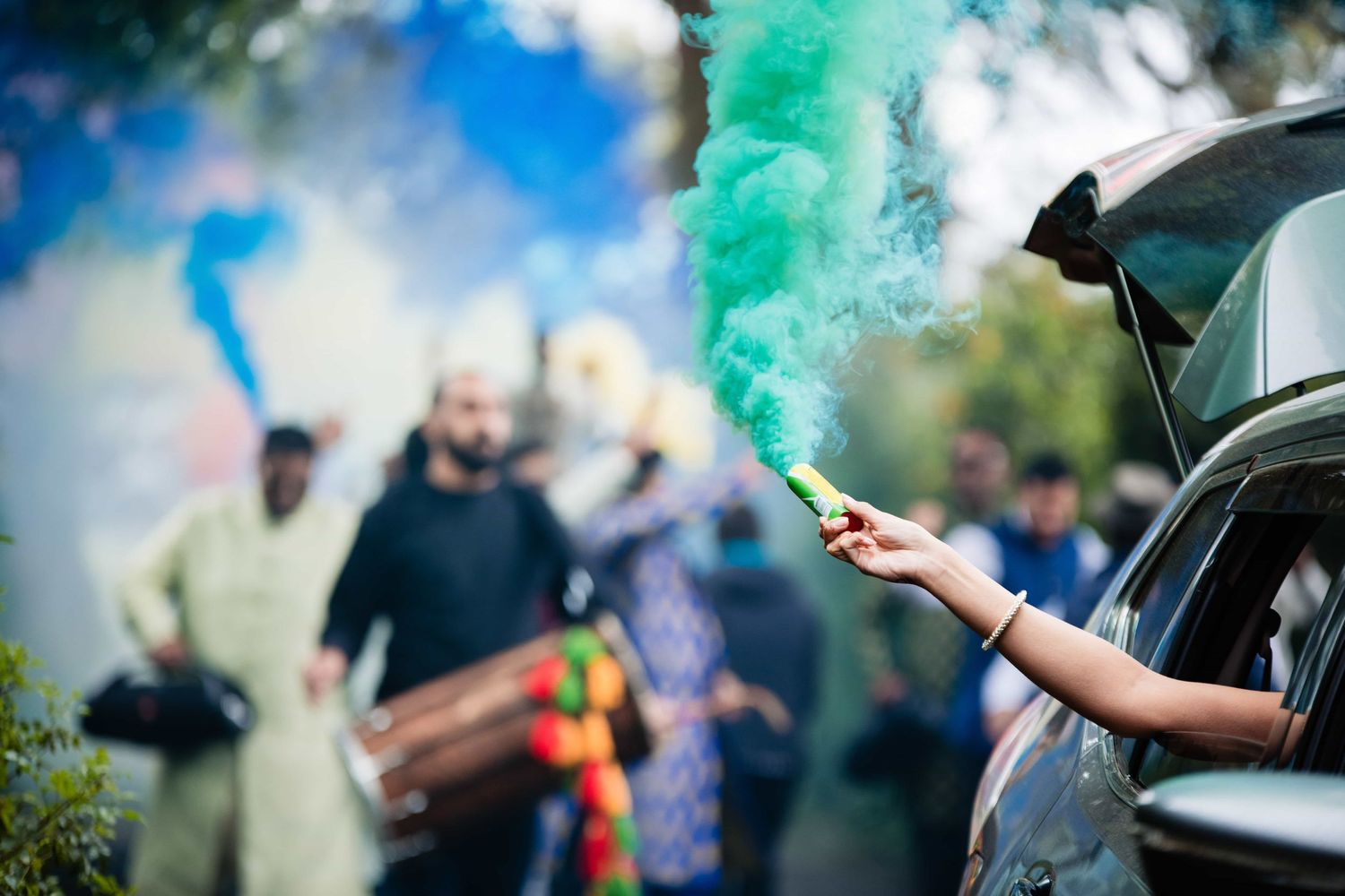 Colorful smoke flares create a festive atmosphere during a wedding celebration.