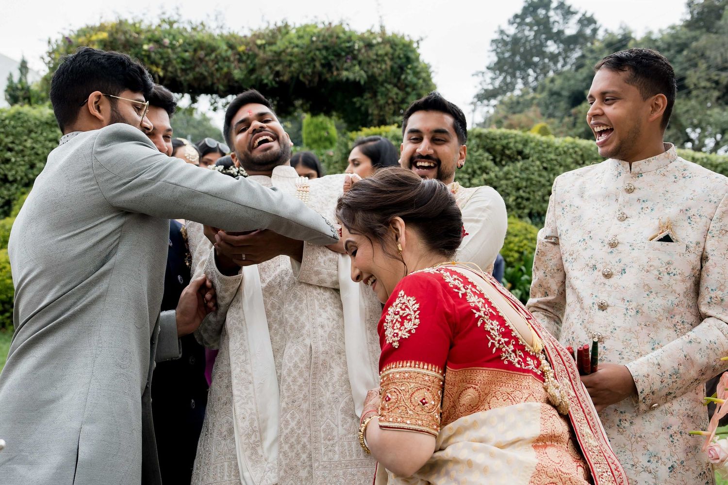 Wedding guests celebrate with joyful expressions during a festive cultural ceremony.