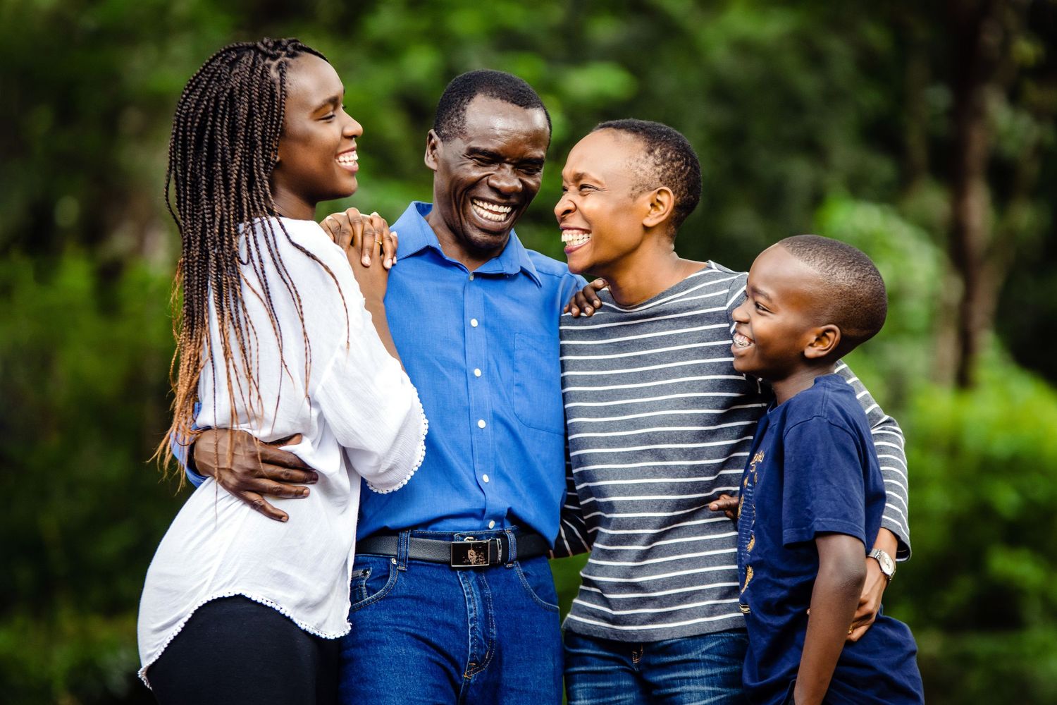 Family enjoying a playful moment together outdoors in a lush green park setting.
