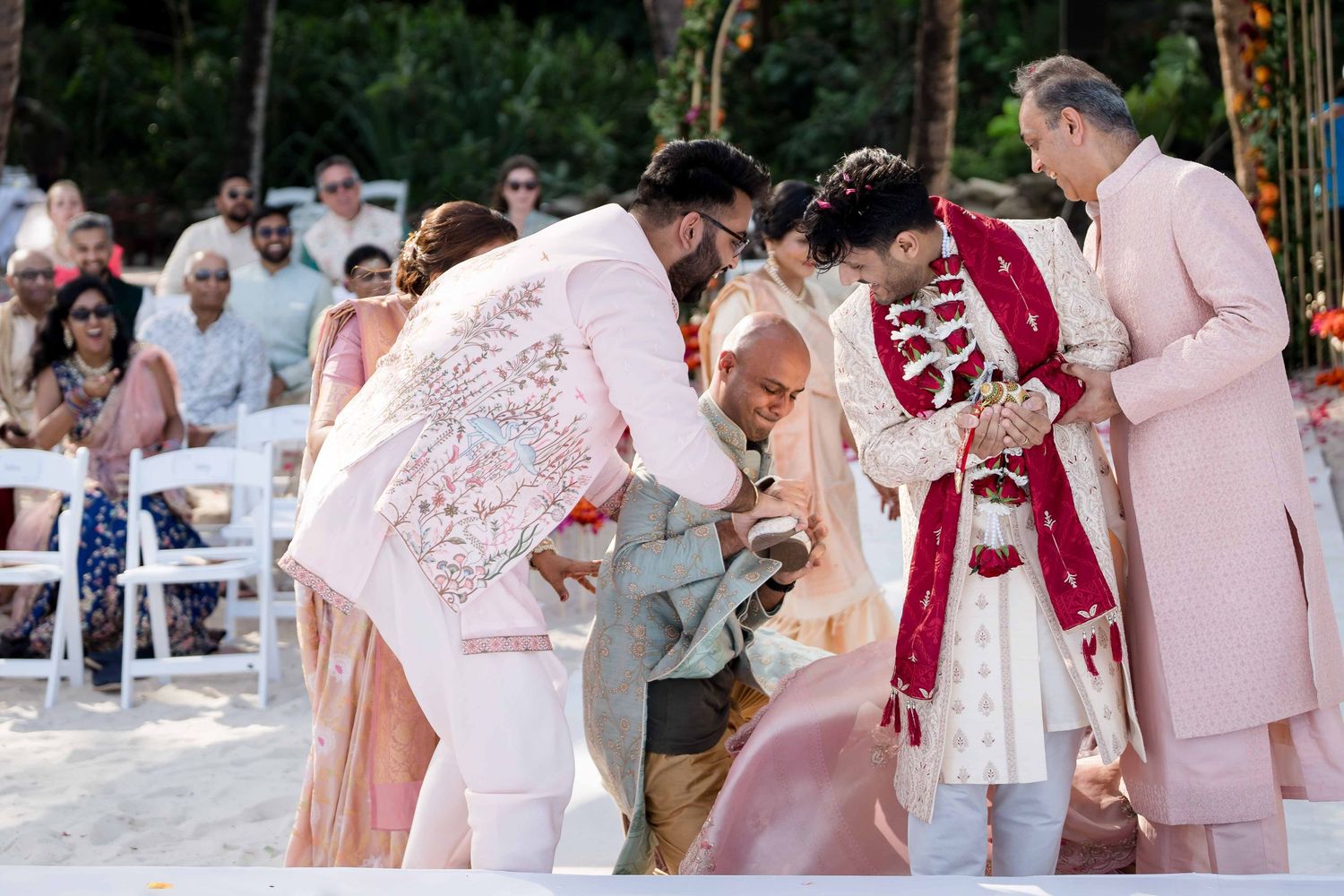 Wedding party dancing together during outdoor reception celebration with guests in pink and white attire.