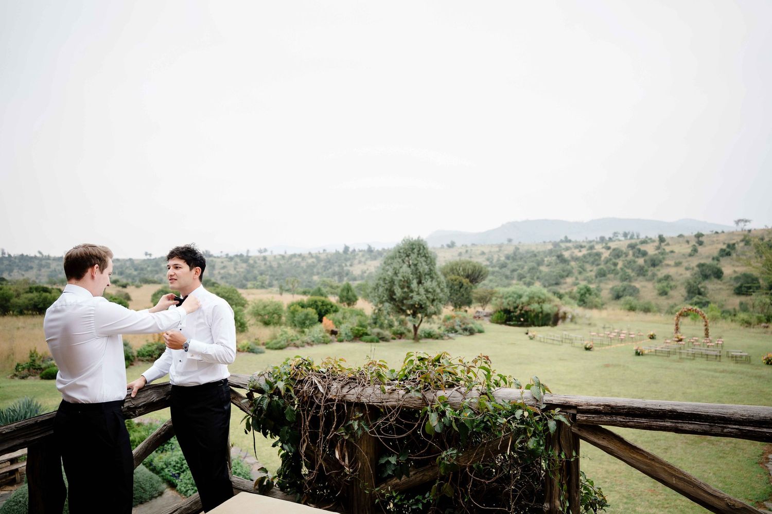 A couple shares an intimate moment during their outdoor wedding ceremony at a scenic hilltop venue.
